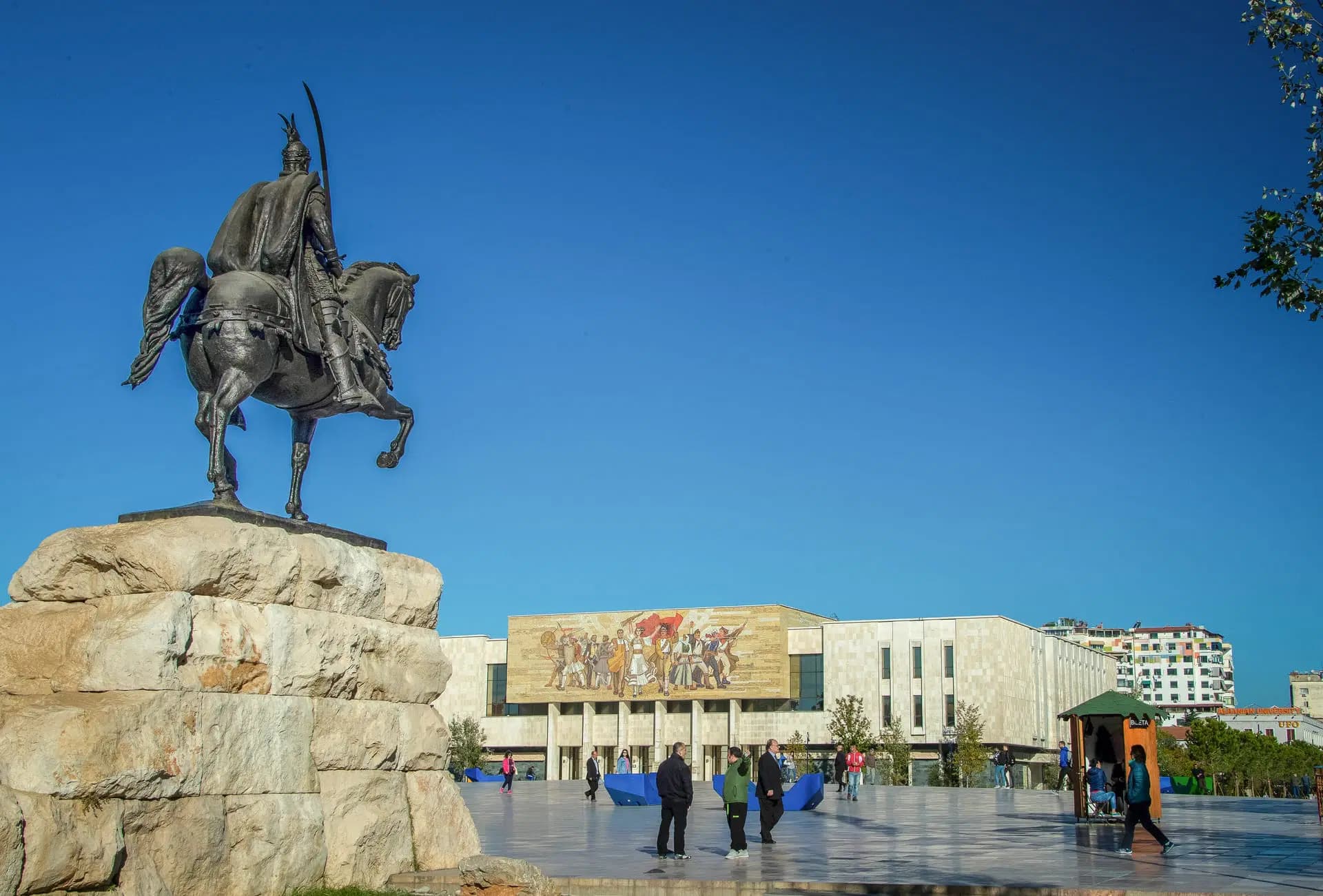 Al centro di Tirana si trova Piazza Skanderbeg, una vasta piazza di 40.000 metri quadrati intitolata all'eroe nazionale Gjergj Kastrioti Skënderbeu. La piazza è circondata da istituzioni significative, tra cui il Museo Storico Nazionale, il Palazzo della Cultura e l'Opera Nazionale. Una statua di Skanderbeg domina la piazza, simboleggiando la resilienza e l'orgoglio dell'Albania.
